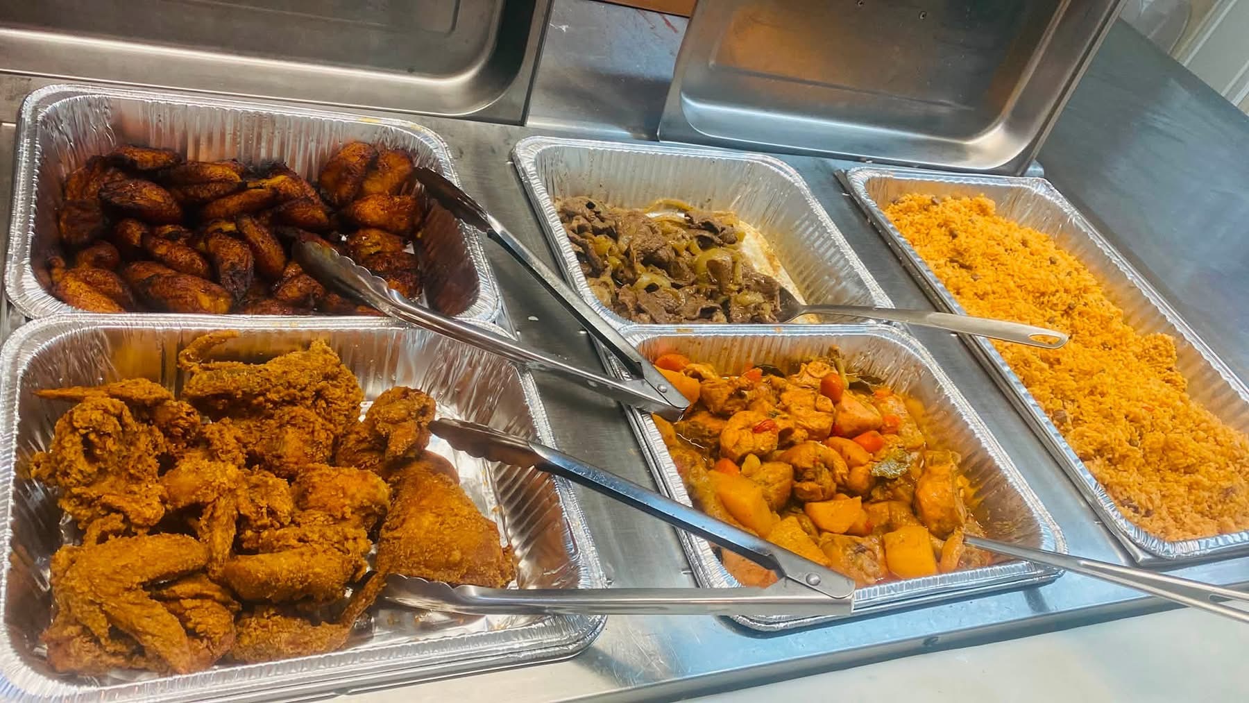 A selection of catering trays with rice, chicken and other dishes