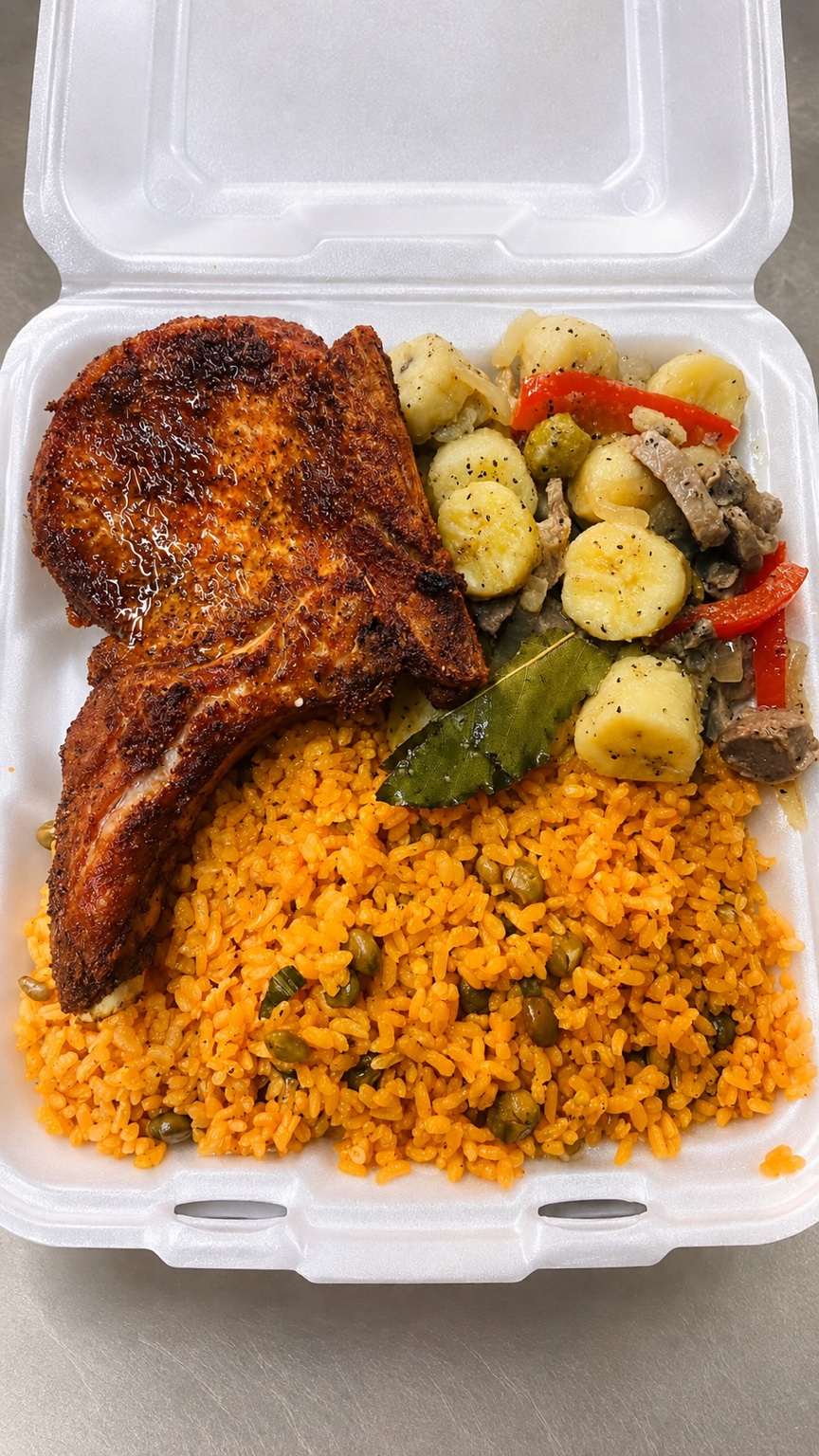 Roasted chicken with yellow rice and vegetables in a takeout box