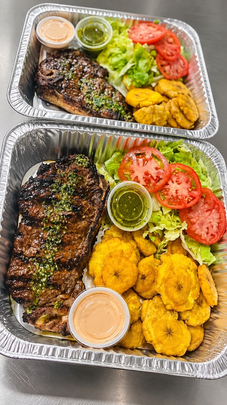 Two steak and tostones platters with salad